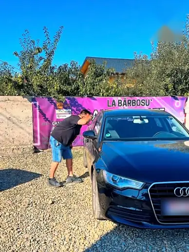 Mașină din parc, lângă banner